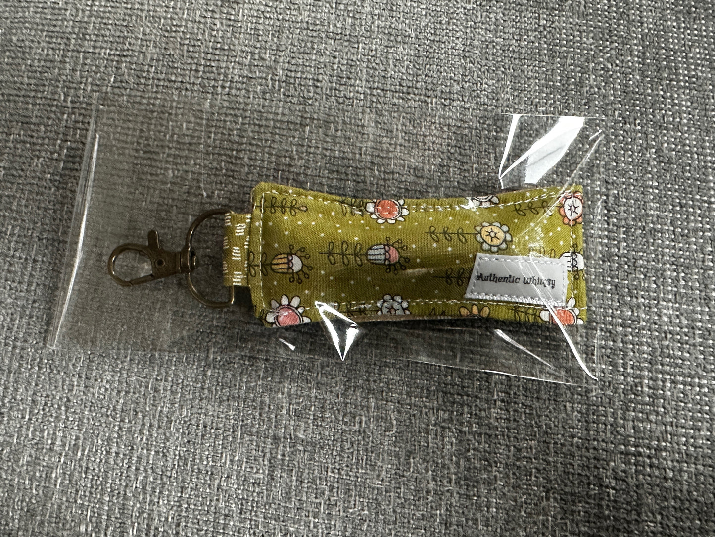 Small fabric pouch with floral design on a gray surface