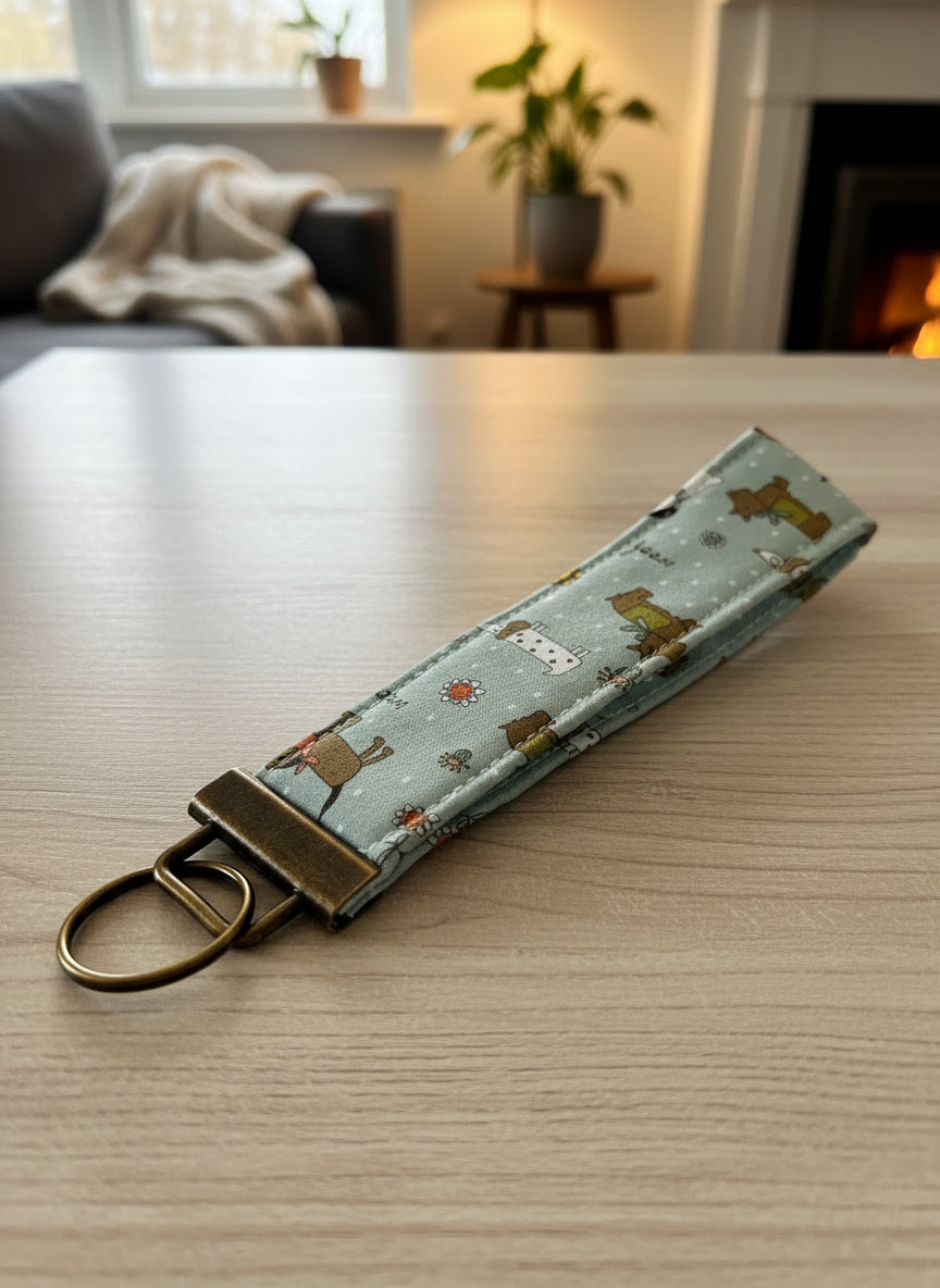 Large blue fabric keychain with dogs and antique brass hardware