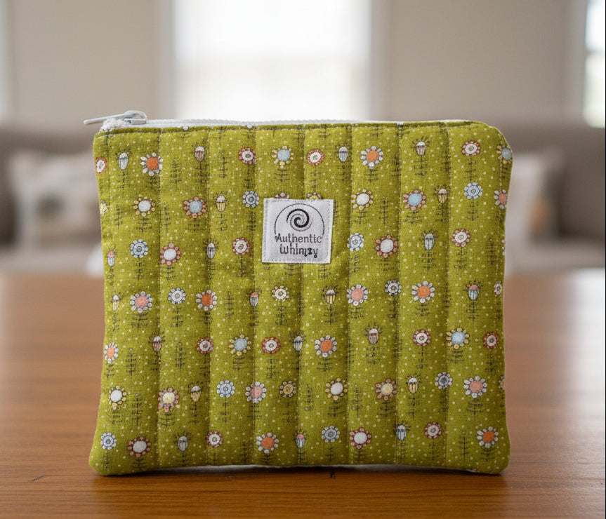 Green patterned pouch with a visible brand label on a gray background