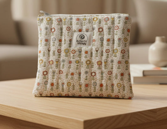 Fabric pouch with floral pattern and visible brand logo on a gray background