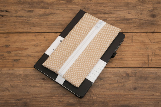 Black notebook with a beige zipper pouch