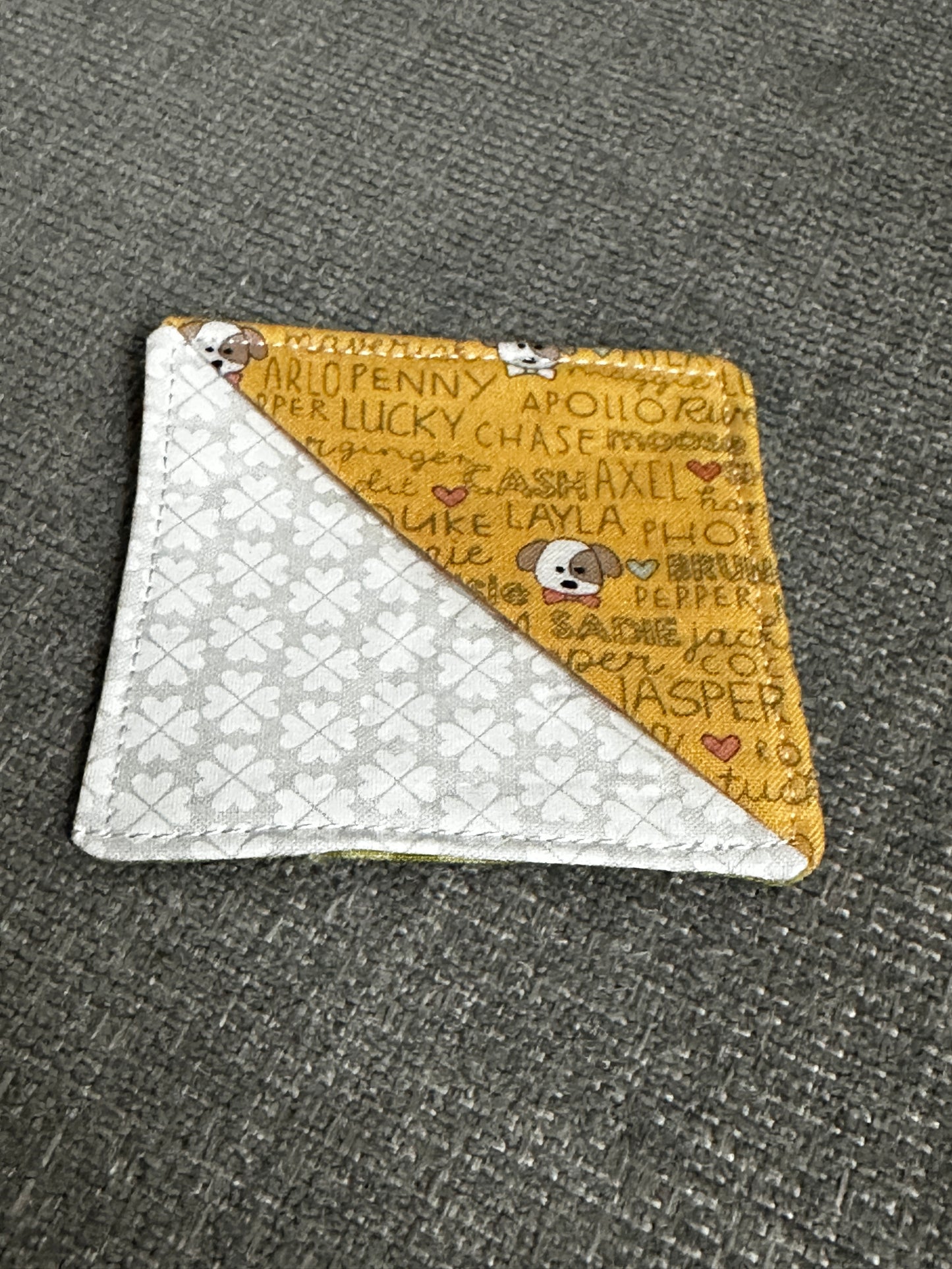 Two-tone cardholder with one side featuring text and the other with a pattern on a textured surface.