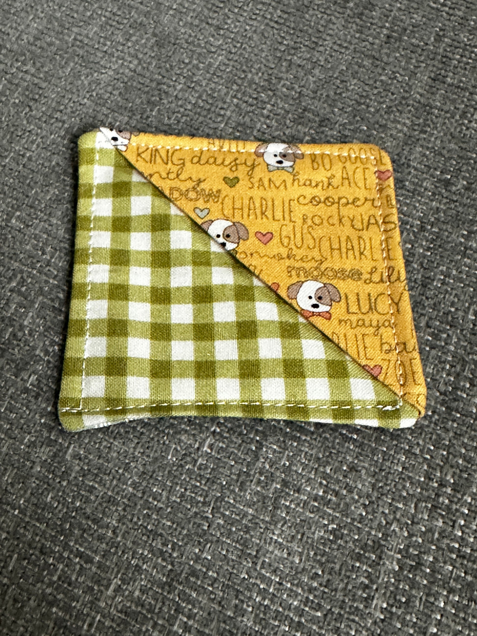 Fabric square with yellow and checkered green sides on a gray textured background