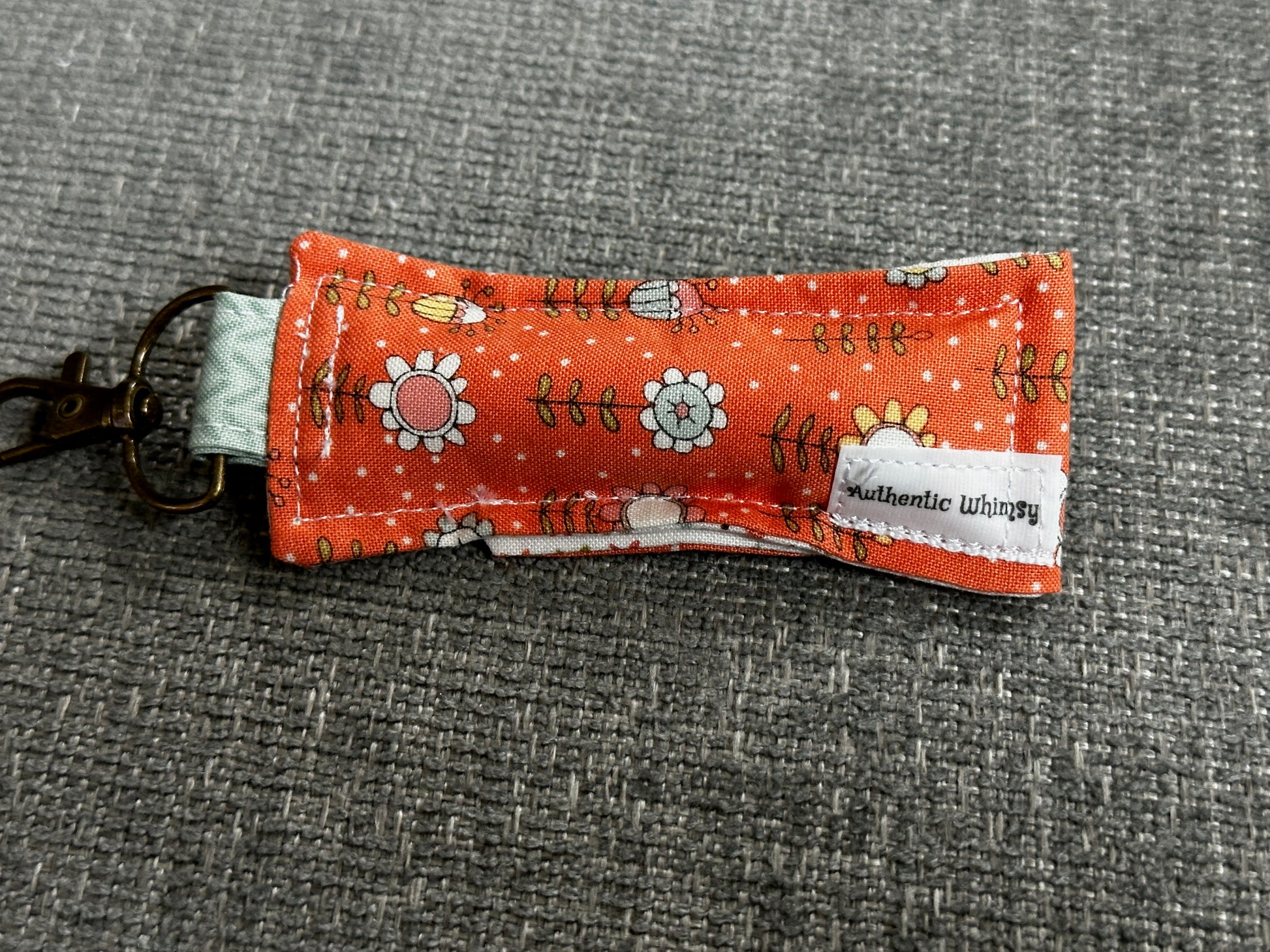 Fabric keychain with floral pattern on a gray textured background