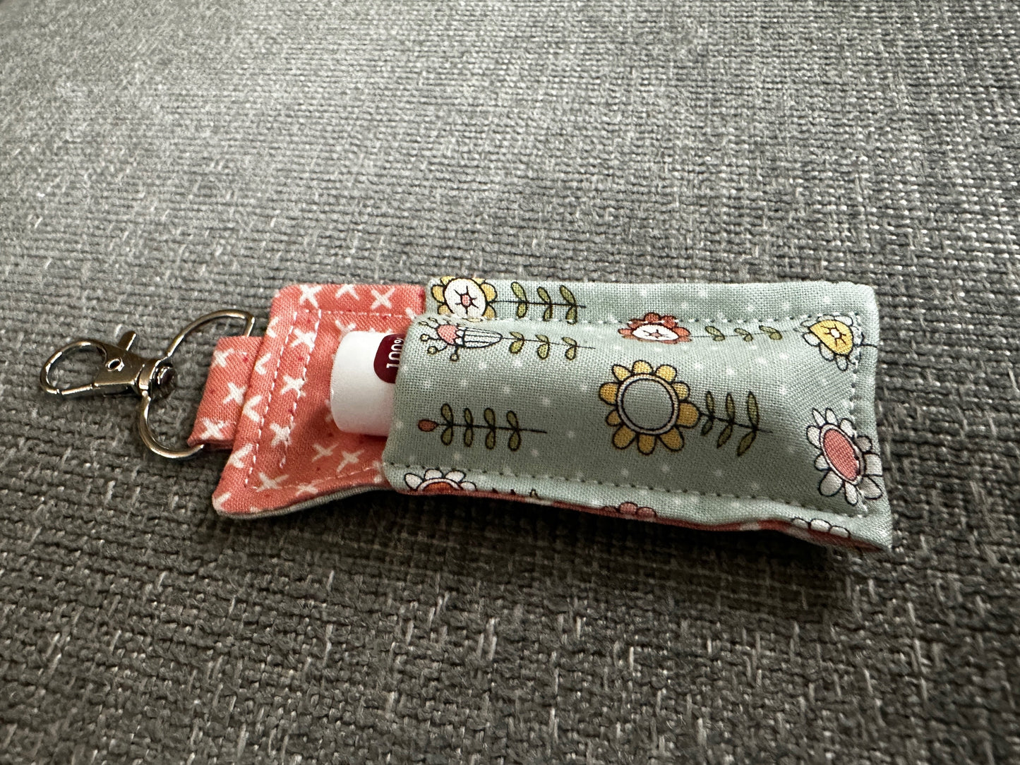Small fabric keychain with floral patterns on a gray surface