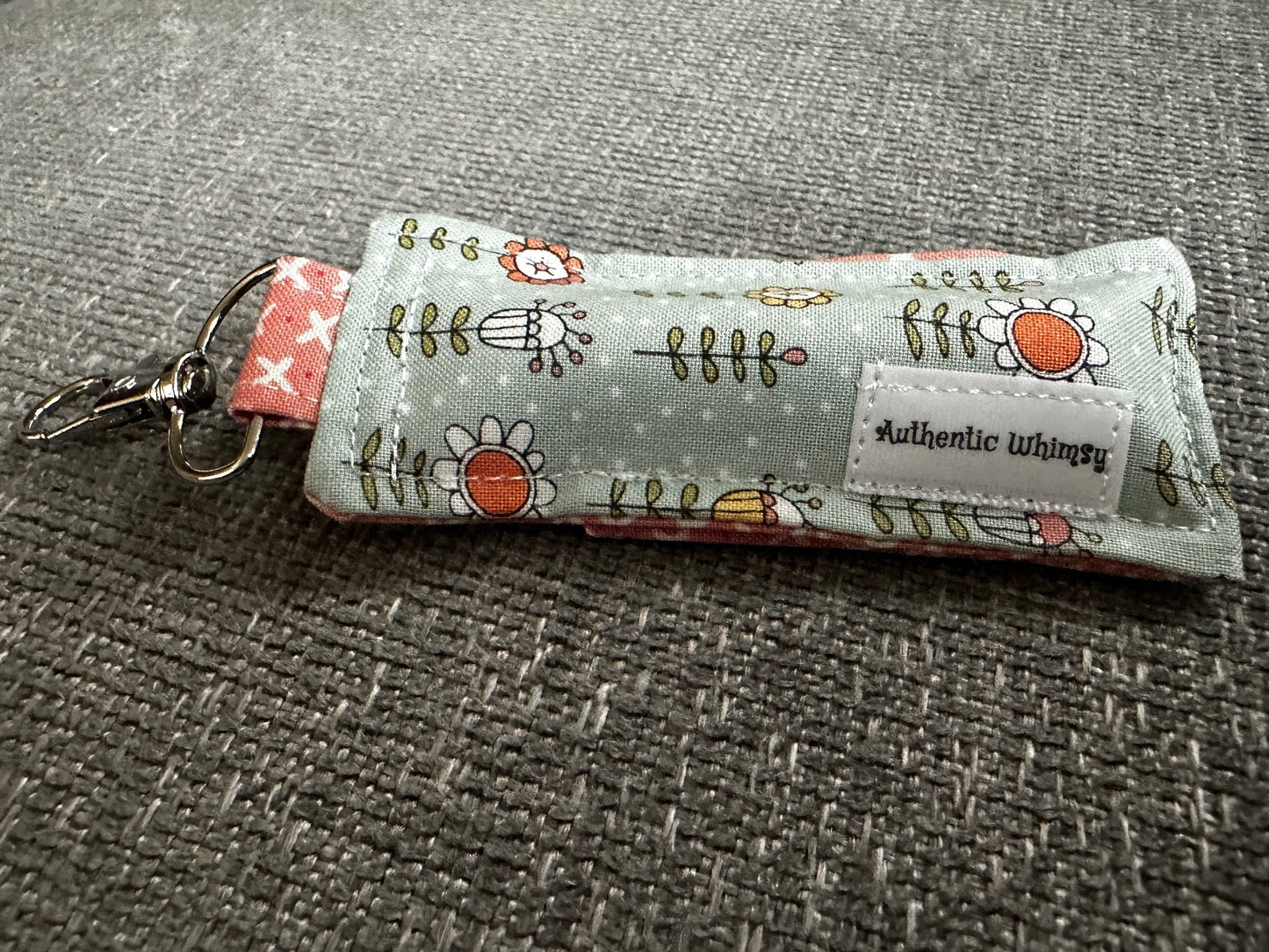 Fabric keychain with floral design on a textured surface