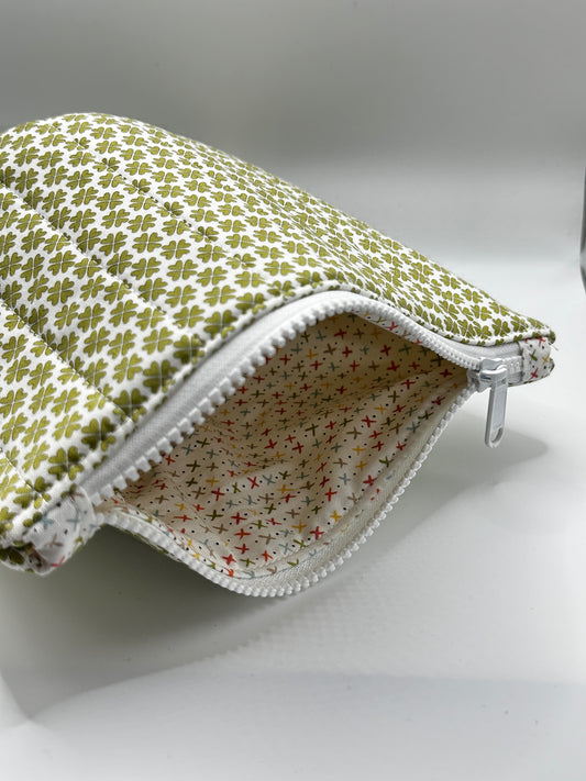 Fabric pouch with green clover pattern on a white background