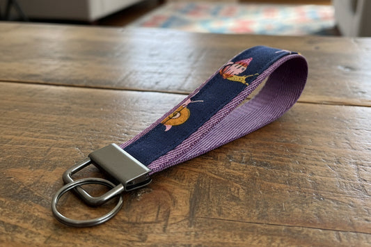 Keychain with cartoon character design on a blue and purple strap 