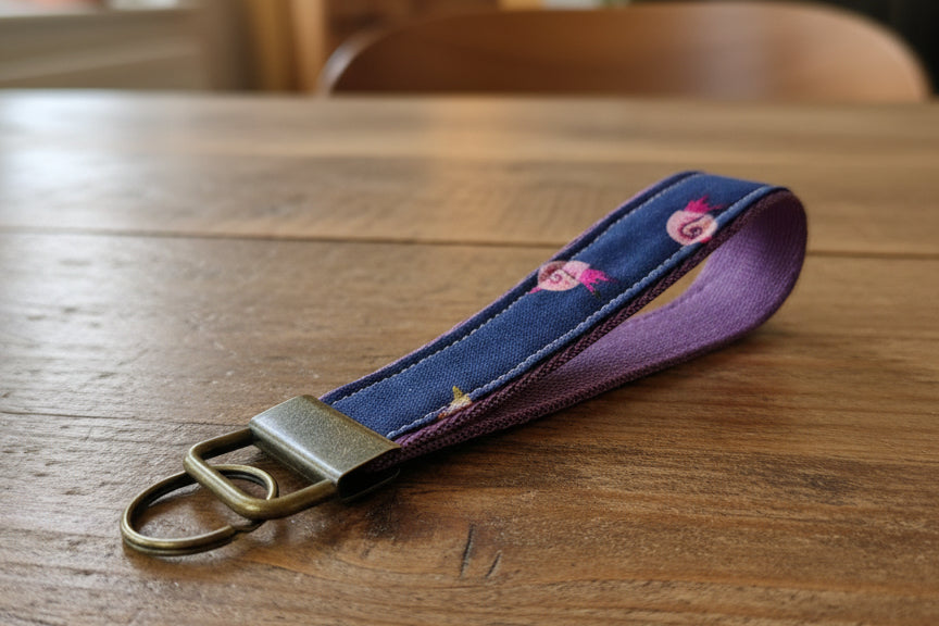 Navy blue keychain with snails on purple strap