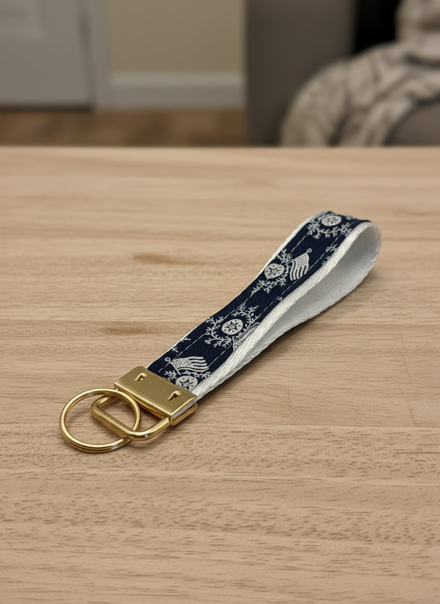Keychain with navy blue strap featuring white patterns on a gray background