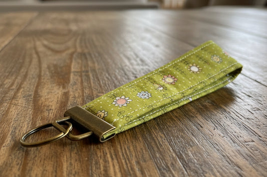 Green fabric keychain with floral patterns