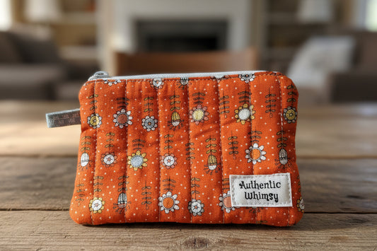 Small orange pouch with floral pattern and 'Authentic Whimsy' label on a white background